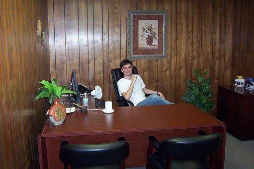 Darin seated at the L-shaped desk in our former Murfreesboro office