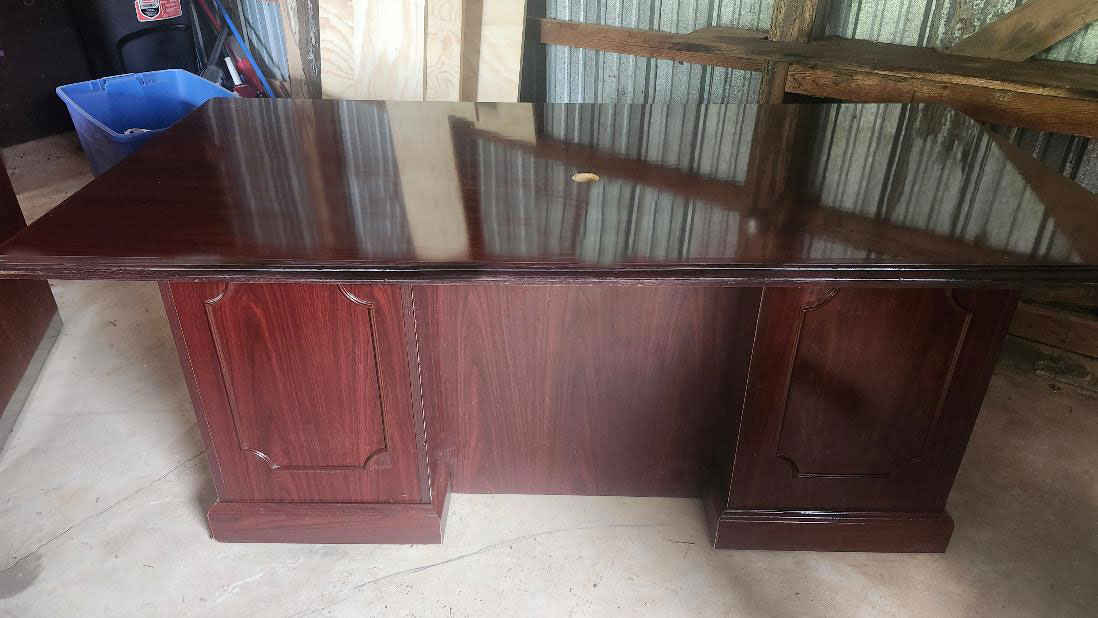 Large rectangular desk with glossy veneer finish in storage